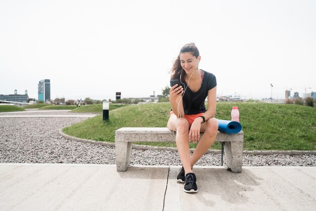 Donna atletica che per mezzo del suo telefono