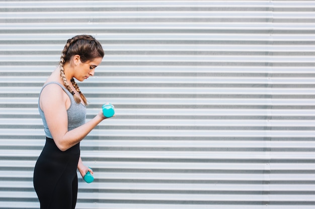 Donna atletica che risolve con i dumbbells