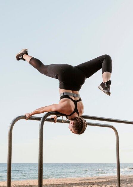 Donna atletica facendo esercizi di fitness all'aperto sulla spiaggia