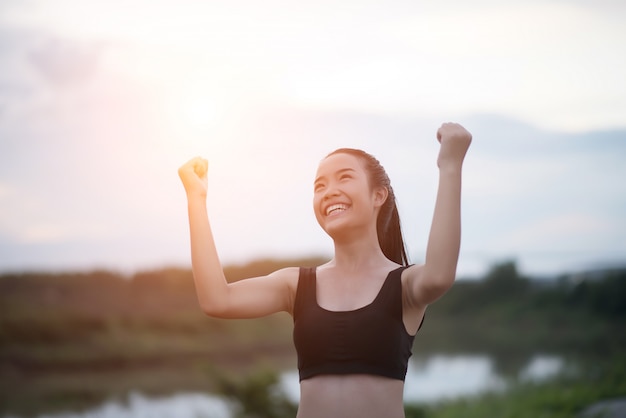 Donna atletica sorridente felice con le armi stese