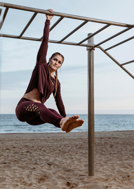 Donna attiva facendo esercizi di fitness all'aperto sulla spiaggia