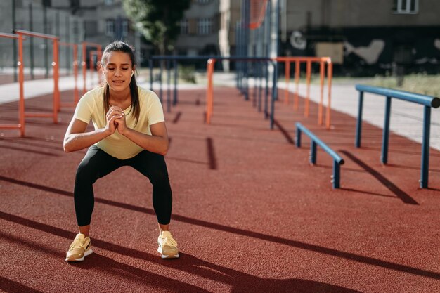 Donna attraente che fa squat profondi all'aria aperta