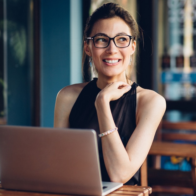 Donna attraente di affari che lavora al suo computer portatile