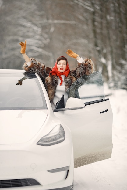 Donna attraente in inverno all'aperto con auto bianca