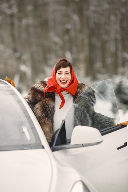 Donna attraente in inverno all'aperto con auto bianca