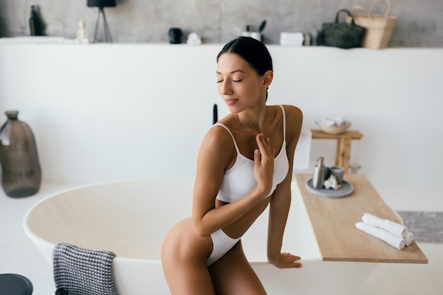 Donna attraente in lingerie in posa vicino al bagno