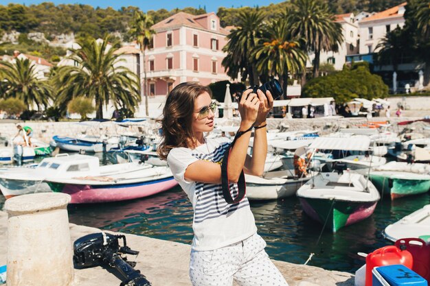 Donna attraente in vacanza in Europa in riva al mare in crociera a scattare foto sulla fotocamera