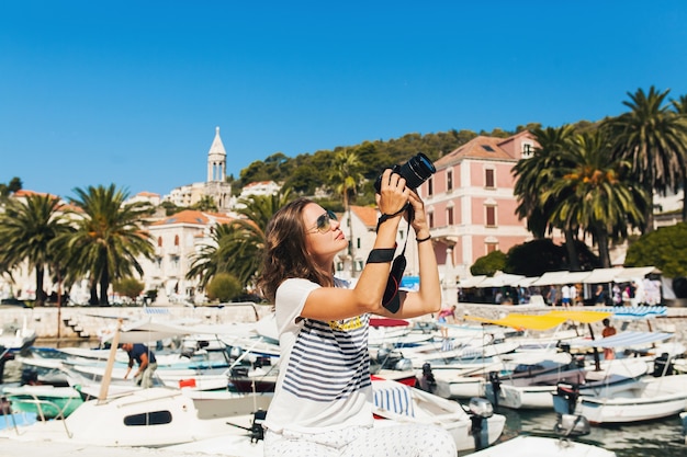 Donna attraente in vacanza in Europa in riva al mare in crociera a scattare foto sulla fotocamera