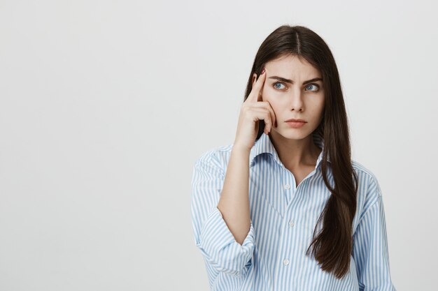 Donna attraente seria che pensa, sguardo da parte concentrato