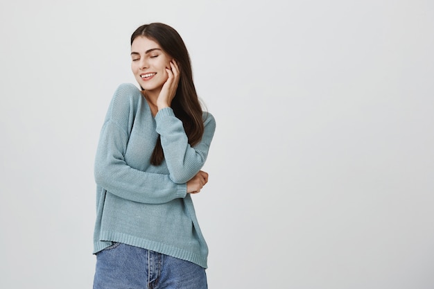 Donna attraente spensierata, felice chiudere gli occhi e sorridere