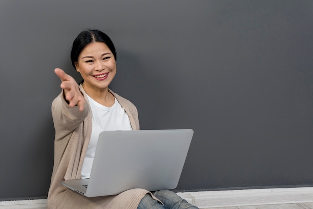 Donna beautfiful che per mezzo del computer portatile