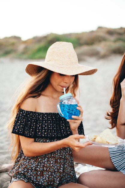 Donna bere bevanda esotica in spiaggia