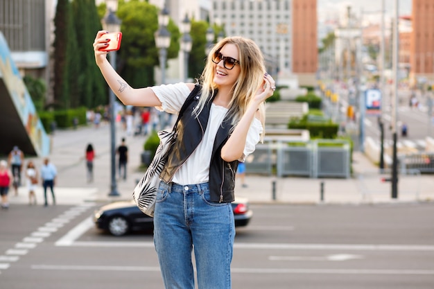 Donna bionda abbastanza turistica che fa selfie sulla strada