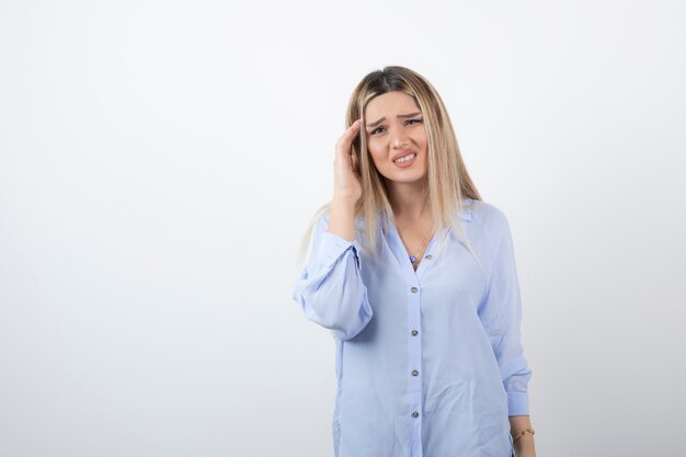 donna bionda che guarda l'obbiettivo su sfondo bianco.