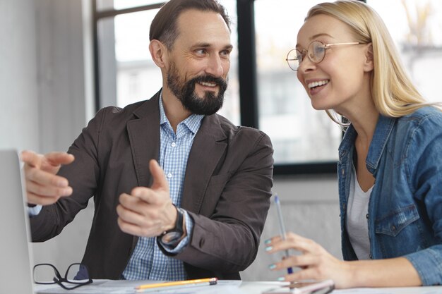 Donna bionda che ha conversazione con un collega di lavoro