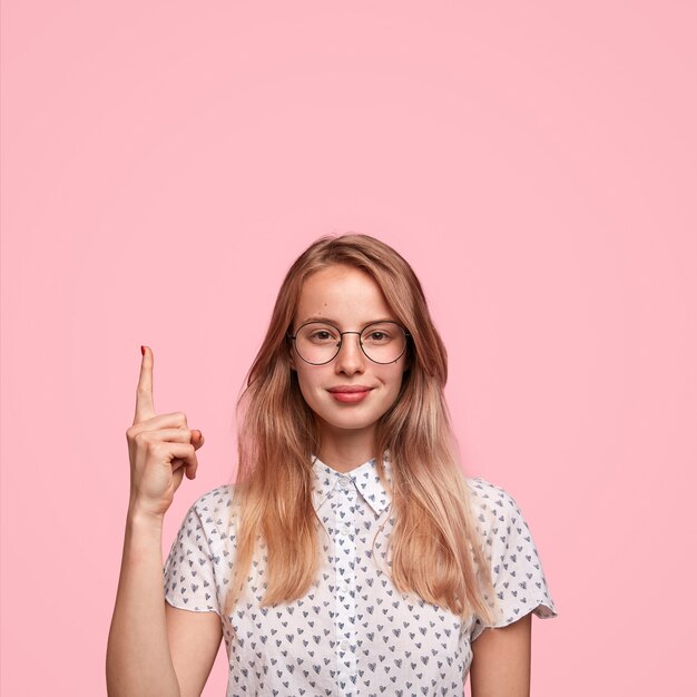 Donna bionda che indossa camicia punteggiata e occhiali da vista