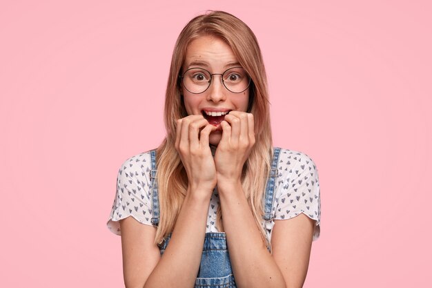 Donna bionda che indossa camicia punteggiata e occhiali da vista