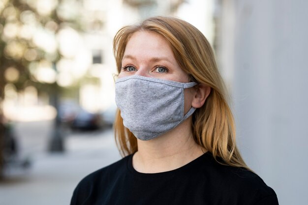 Donna bionda che indossa una maschera nel servizio fotografico all'aperto della città