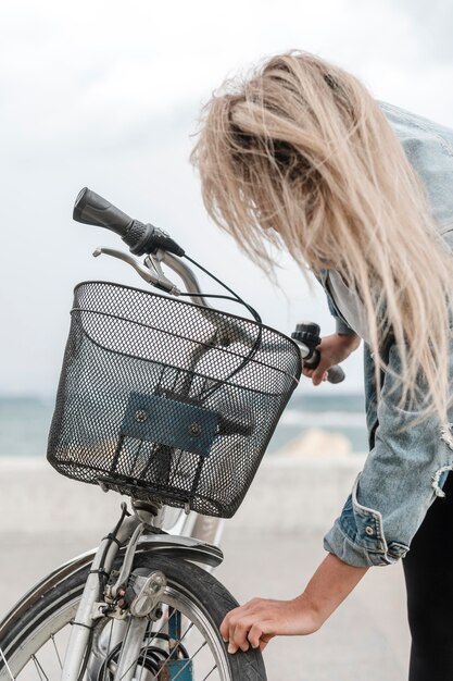 Donna bionda che ripara la sua bici