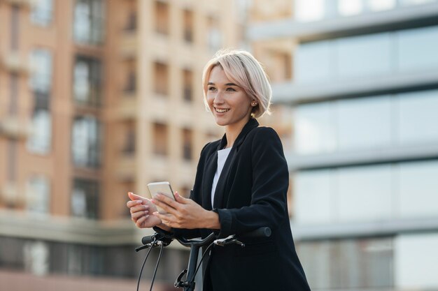 Donna bionda che tiene telefono cellulare