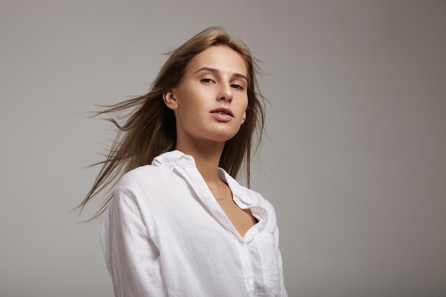 Donna bionda con i capelli volano in aria