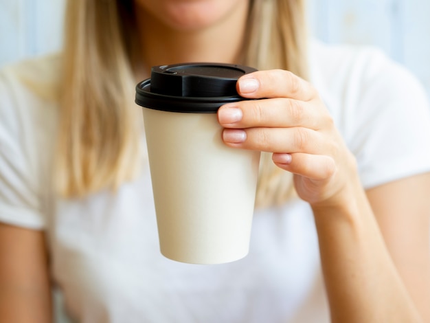 Donna bionda del primo piano con la tazza di caffè