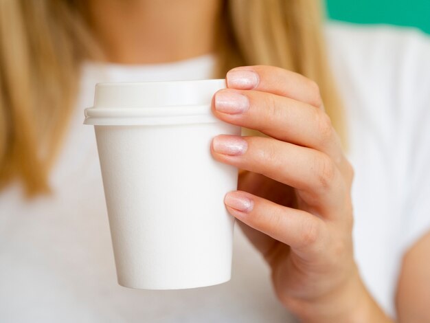 Donna bionda del primo piano con la tazza di caffè