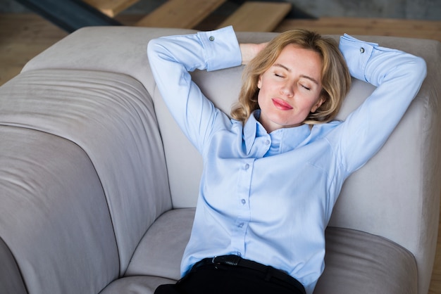 Donna bionda di affari che dorme sullo strato