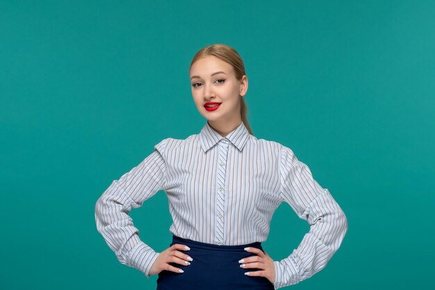 Donna bionda graziosa di affari in vestito dell'ufficio che mette le mani sulla vita