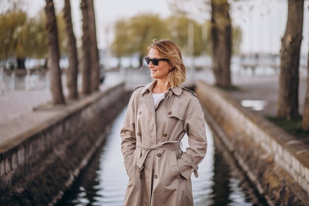 Donna bionda in cappotto fuori nel parco