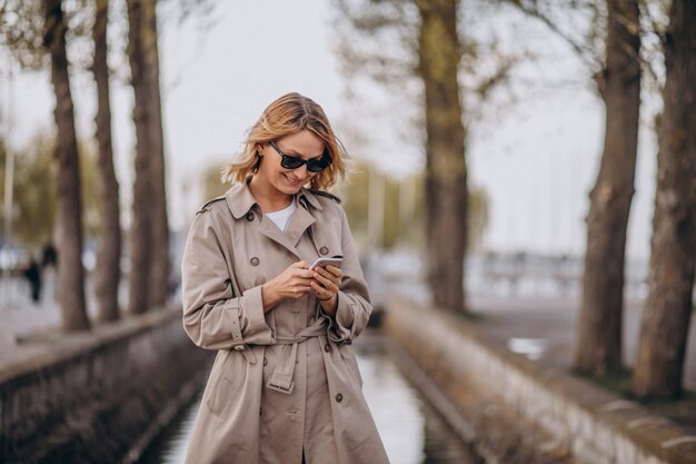 Donna bionda in cappotto fuori nel parco