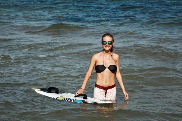 Donna bionda in spiaggia con il surf