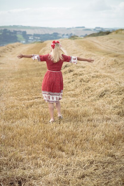 Donna bionda spensierata che sta nel campo