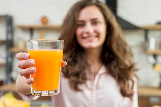 Donna bruna che beve succo d&#39;arancia