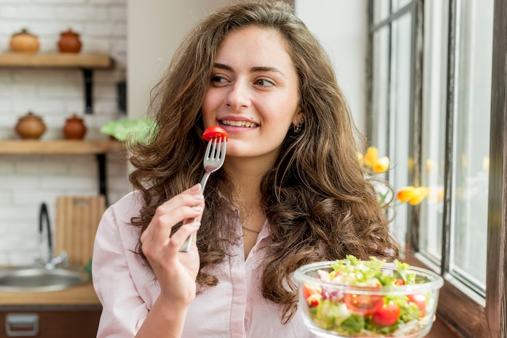 Foto gratuito donna bruna che mangia un'insalata