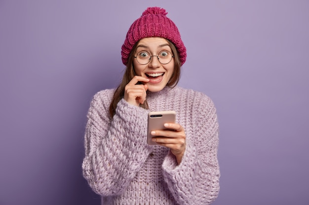 Donna castana che indossa cappello e maglione lavorato a maglia