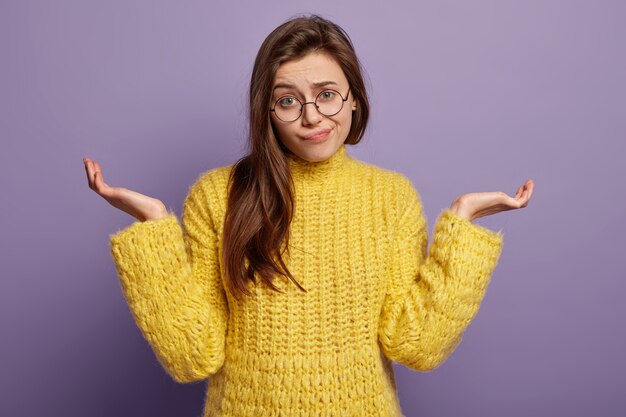 Donna castana che indossa un maglione giallo