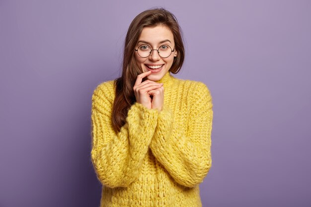 Donna castana che indossa un maglione giallo