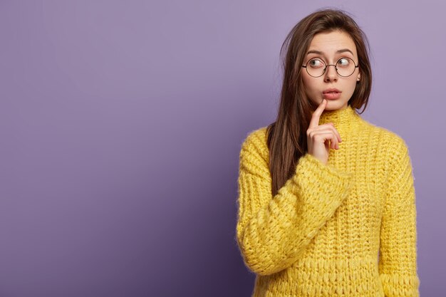 Donna castana che indossa un maglione giallo