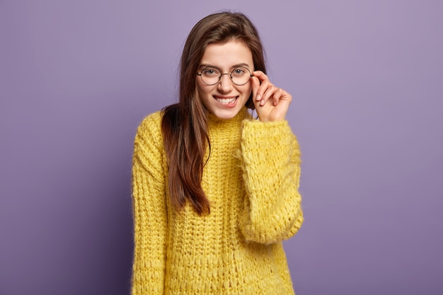 Donna castana che indossa un maglione giallo