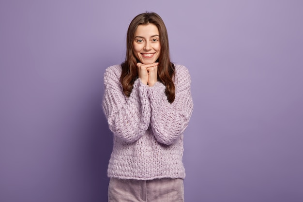 Donna castana che indossa un maglione lavorato a maglia