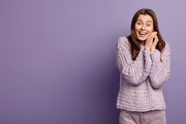 Donna castana che indossa un maglione lavorato a maglia