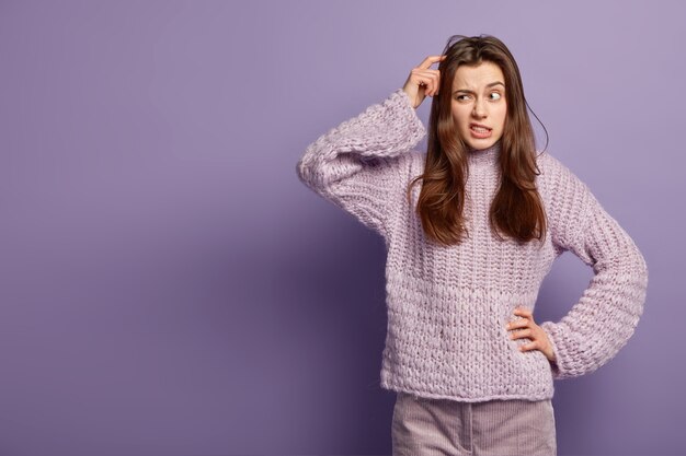 Donna castana che indossa un maglione lavorato a maglia