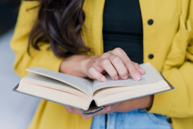 Donna castana del primo piano con il libro