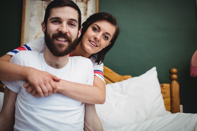 Donna che abbraccia l'uomo sul letto