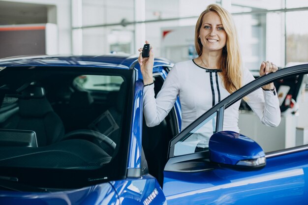 Donna che acquista una nuova auto in un salone di auto