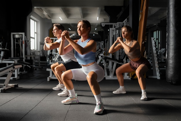 Donna che aiuta l'uomo in palestra