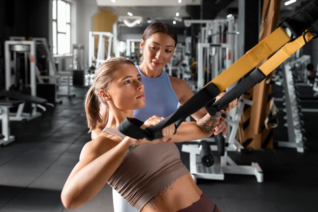 Donna che aiuta l'uomo in palestra