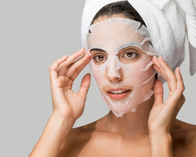 Donna che applica maschera di bellezza viso