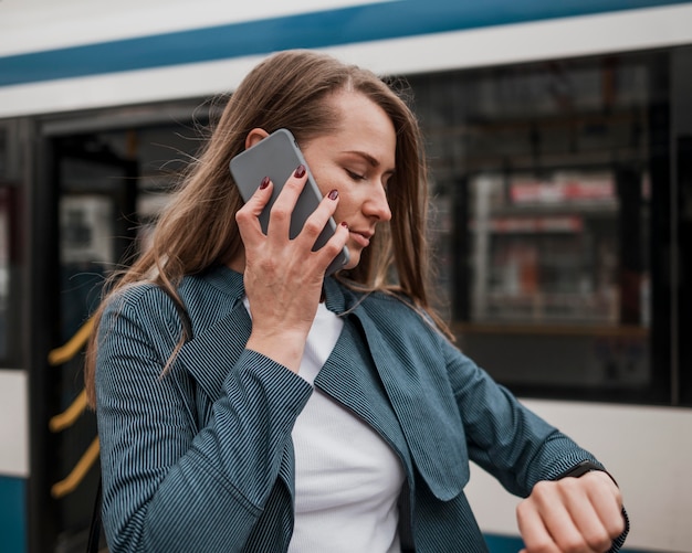 Donna che aspetta l'autobus e controlla l'ora